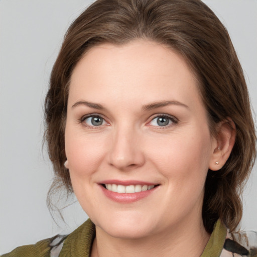 Joyful white young-adult female with medium  brown hair and green eyes