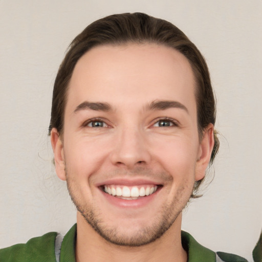 Joyful white young-adult male with short  brown hair and green eyes