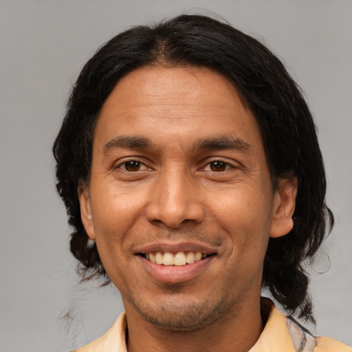 Joyful latino adult male with medium  black hair and brown eyes