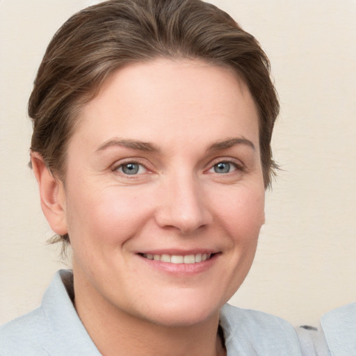 Joyful white young-adult female with short  brown hair and grey eyes