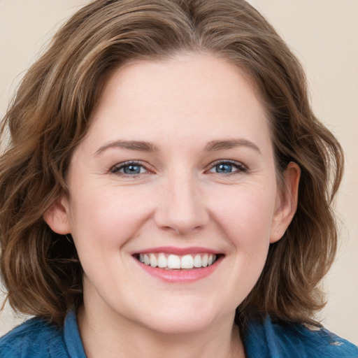 Joyful white young-adult female with medium  brown hair and blue eyes