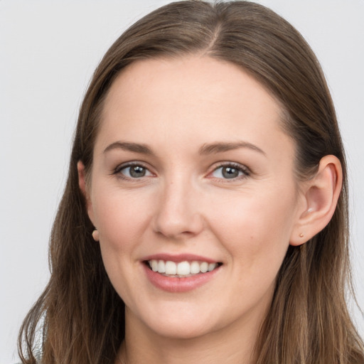 Joyful white young-adult female with long  brown hair and grey eyes