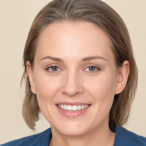 Joyful white young-adult female with medium  brown hair and grey eyes