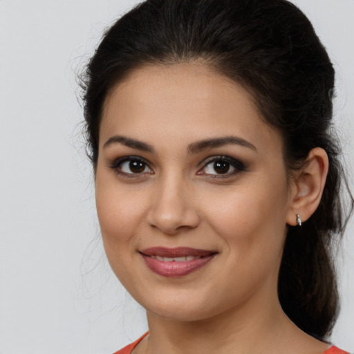 Joyful latino young-adult female with medium  brown hair and brown eyes