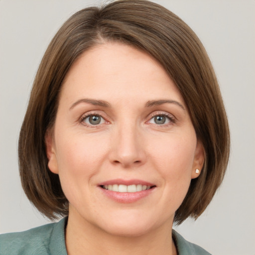 Joyful white young-adult female with medium  brown hair and grey eyes