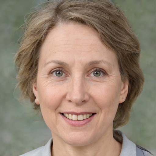 Joyful white adult female with medium  brown hair and grey eyes