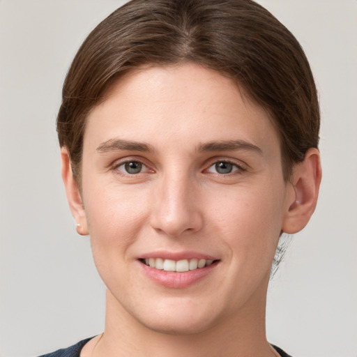 Joyful white young-adult female with short  brown hair and grey eyes