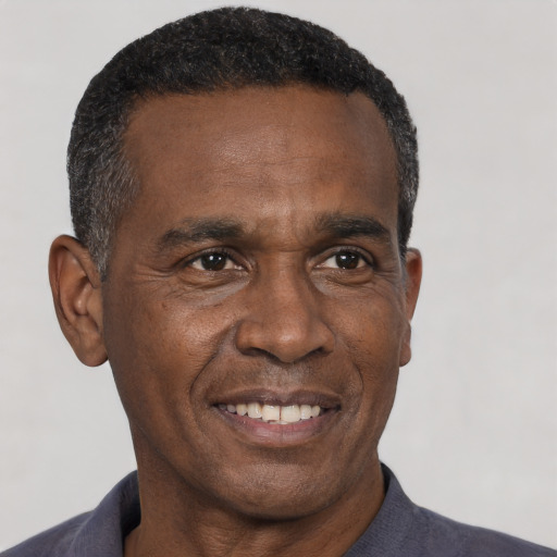 Joyful black adult male with short  black hair and brown eyes