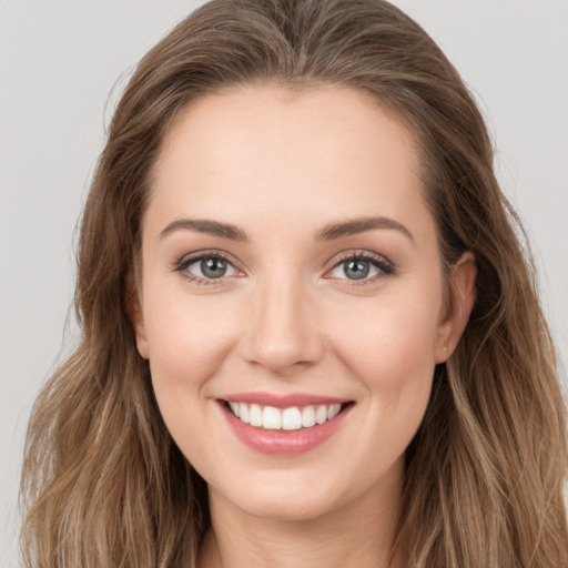 Joyful white young-adult female with long  brown hair and grey eyes