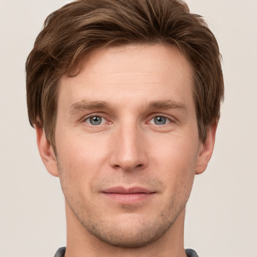 Joyful white young-adult male with short  brown hair and grey eyes