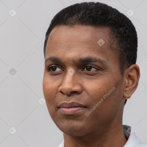 Joyful black young-adult male with short  black hair and brown eyes