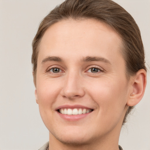 Joyful white young-adult female with short  brown hair and grey eyes