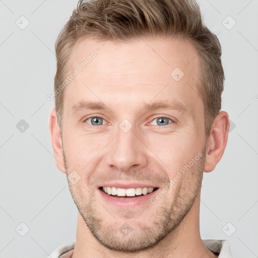 Joyful white young-adult male with short  brown hair and grey eyes