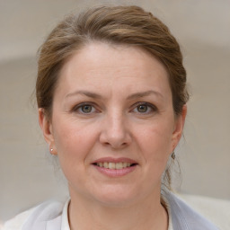 Joyful white adult female with medium  brown hair and grey eyes