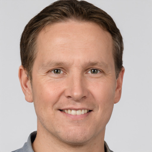 Joyful white adult male with short  brown hair and grey eyes