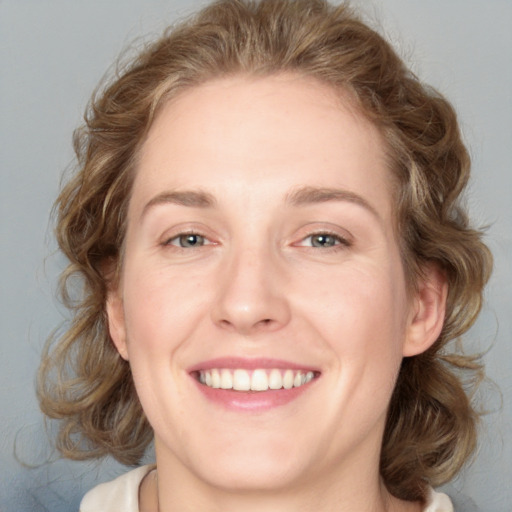 Joyful white young-adult female with medium  brown hair and blue eyes