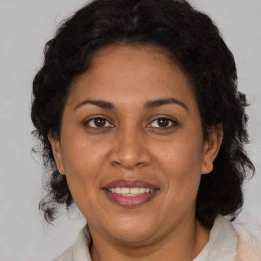 Joyful latino adult female with medium  brown hair and brown eyes