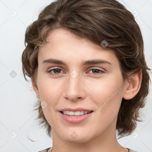 Joyful white young-adult female with medium  brown hair and grey eyes