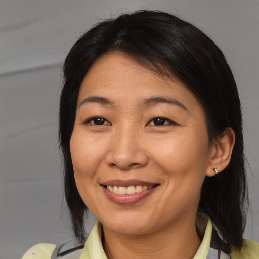 Joyful asian adult female with medium  brown hair and brown eyes