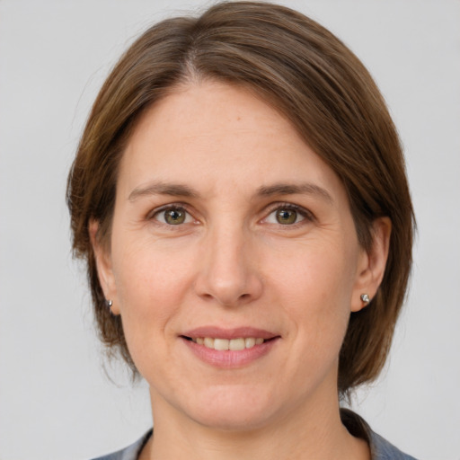 Joyful white adult female with medium  brown hair and grey eyes