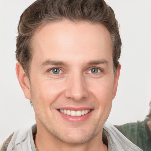 Joyful white young-adult male with short  brown hair and grey eyes