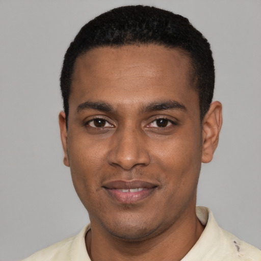 Joyful black young-adult male with short  black hair and brown eyes