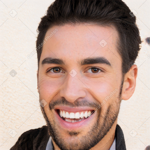 Joyful white young-adult male with short  black hair and brown eyes