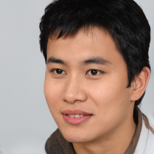 Joyful asian young-adult male with short  black hair and brown eyes