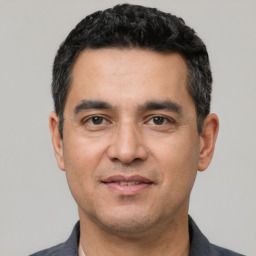 Joyful white adult male with short  black hair and brown eyes