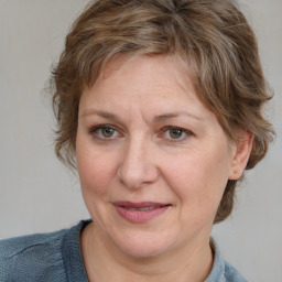 Joyful white adult female with medium  brown hair and blue eyes