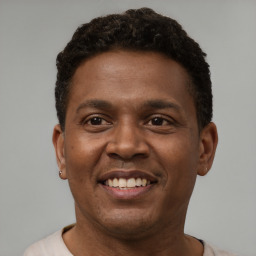 Joyful latino young-adult male with short  brown hair and brown eyes