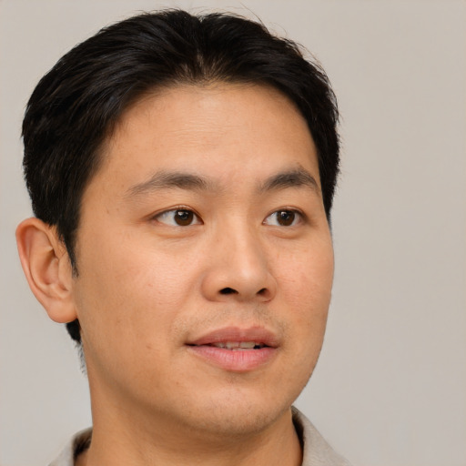 Joyful asian young-adult male with short  brown hair and brown eyes