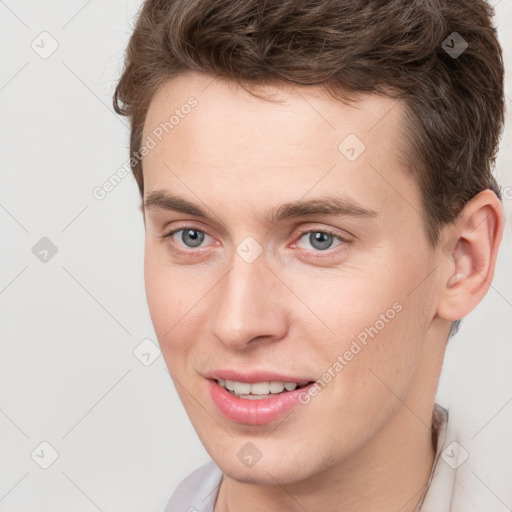 Joyful white young-adult male with short  brown hair and grey eyes