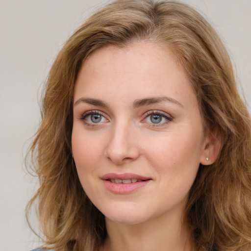 Joyful white young-adult female with long  brown hair and blue eyes