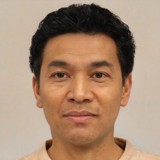 Joyful asian adult male with short  black hair and brown eyes
