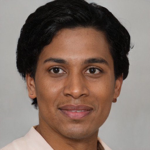 Joyful latino young-adult male with short  brown hair and brown eyes