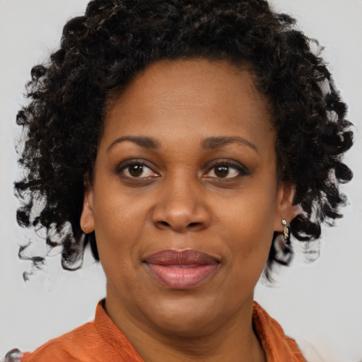 Joyful black adult female with medium  brown hair and brown eyes