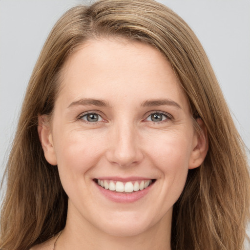 Joyful white young-adult female with long  brown hair and grey eyes