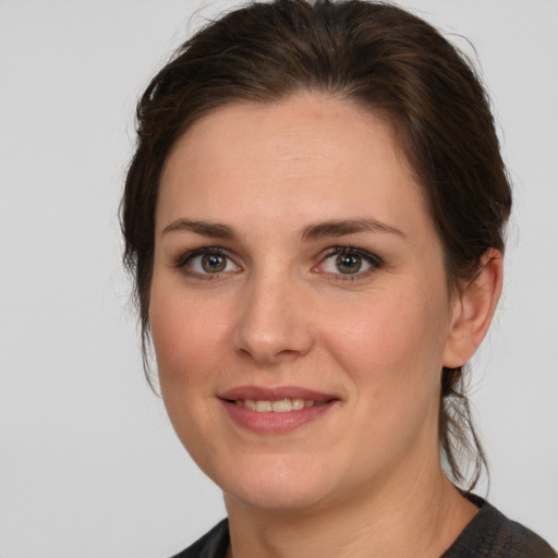 Joyful white young-adult female with medium  brown hair and grey eyes