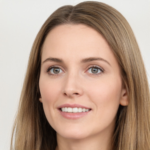 Joyful white young-adult female with long  brown hair and green eyes