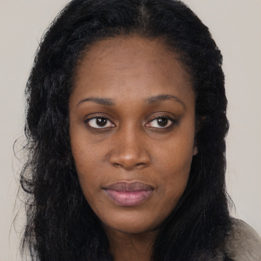 Joyful black young-adult female with long  black hair and brown eyes