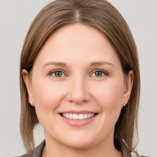 Joyful white young-adult female with medium  brown hair and grey eyes