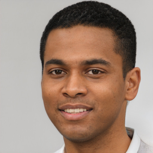 Joyful black young-adult male with short  black hair and brown eyes