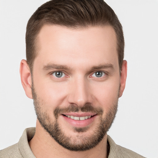 Joyful white young-adult male with short  brown hair and grey eyes