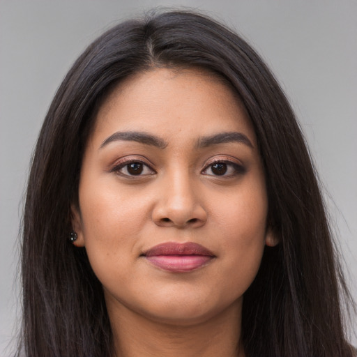 Joyful latino young-adult female with long  brown hair and brown eyes