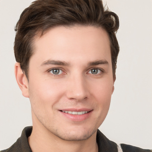 Joyful white young-adult male with short  brown hair and grey eyes