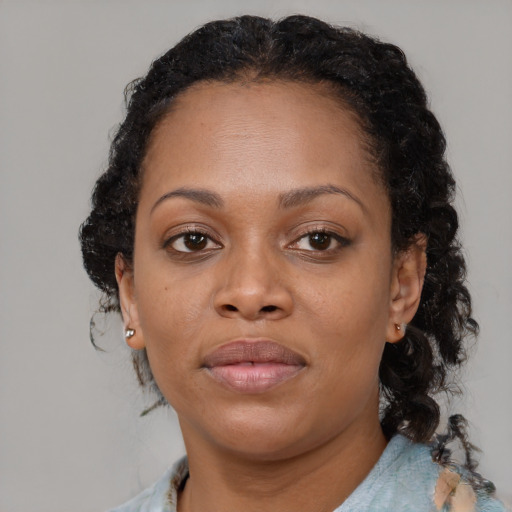 Joyful black adult female with medium  brown hair and brown eyes