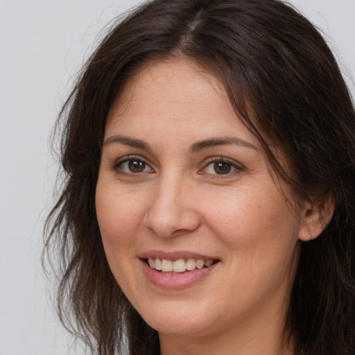 Joyful white adult female with long  brown hair and brown eyes