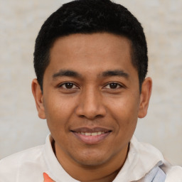 Joyful latino young-adult male with short  black hair and brown eyes