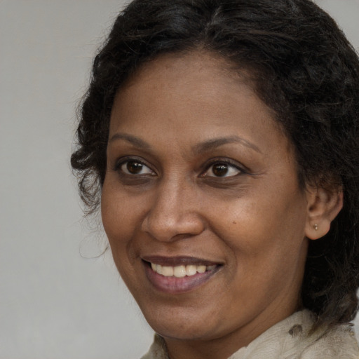 Joyful black adult female with long  brown hair and brown eyes